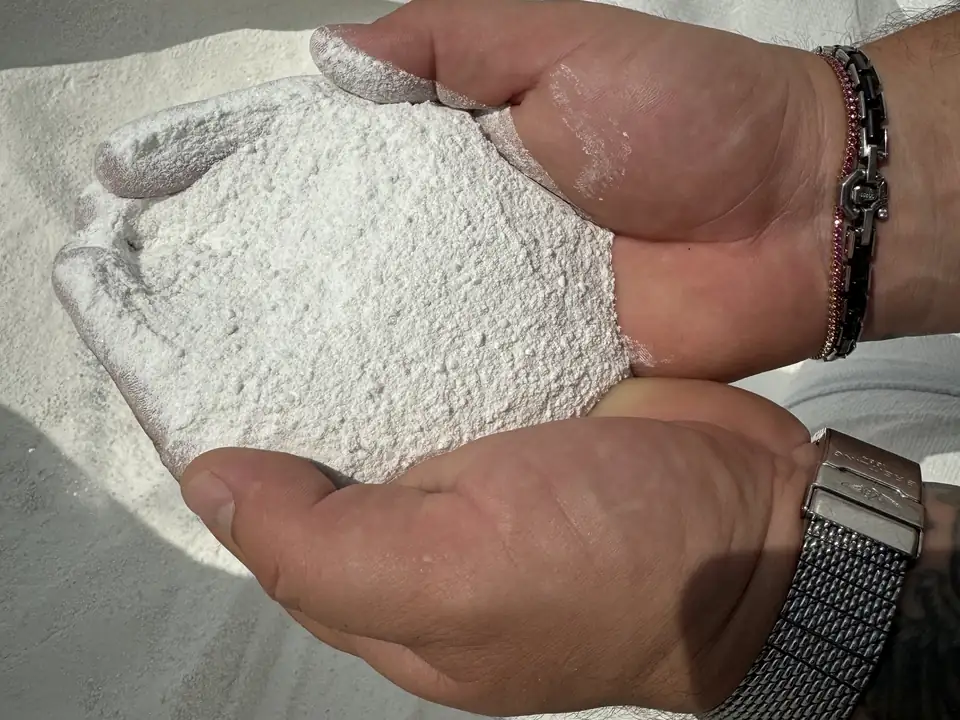Görögországból származó márványpor egy marékban – a prémium fehér kerítéselemek egyik alapanyaga