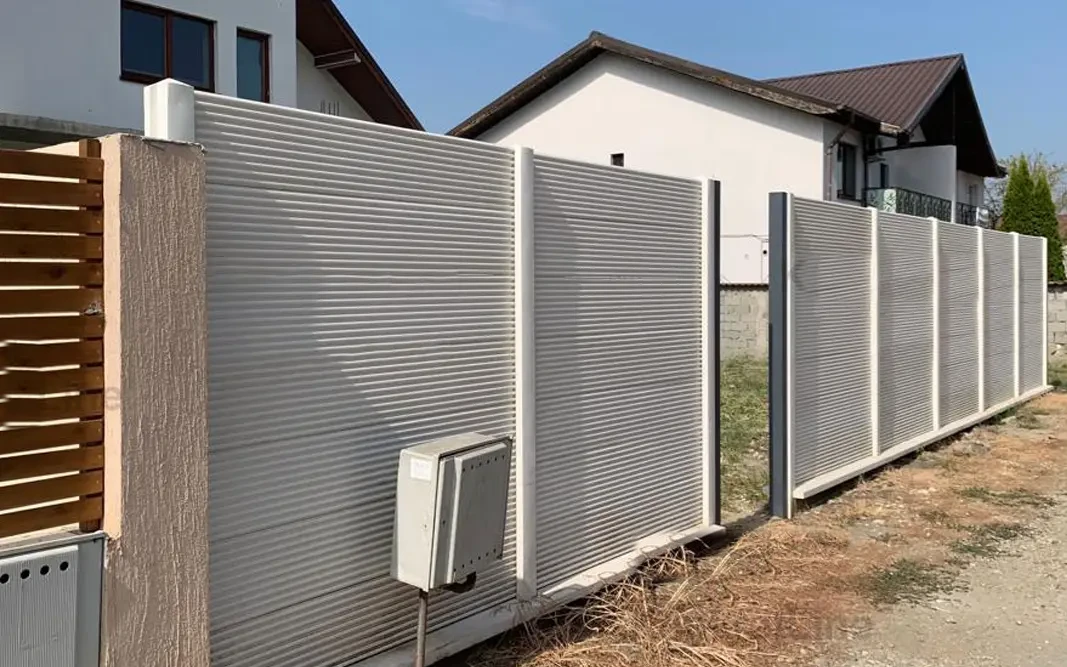 Betonkerítés finom vízszintes domborművel ház előtt